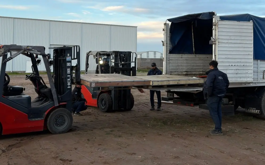 Dos autoelevadores Heli cargan entre ambos una plataforma sobre un camión