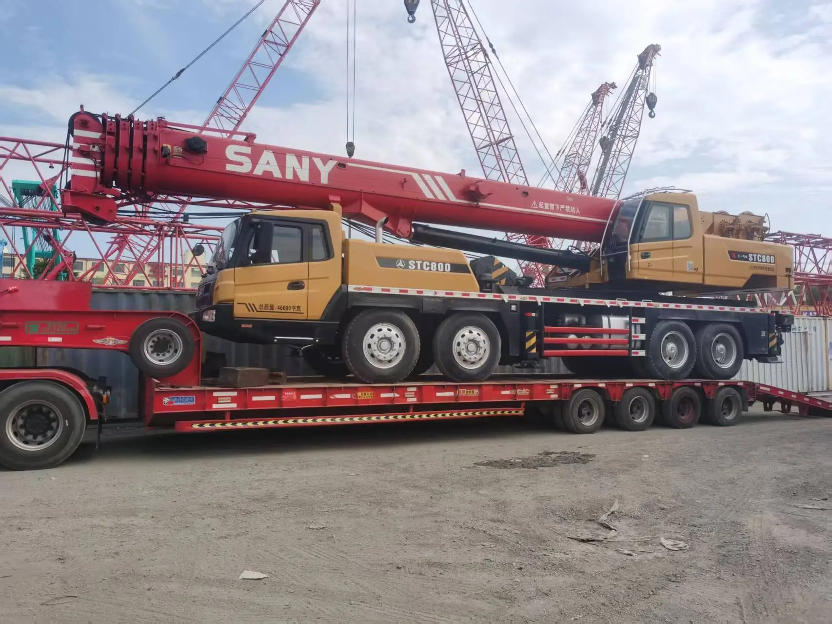 Grúa de 80 t sobre carretón, con la pluma roja recogida, lista para el traslado