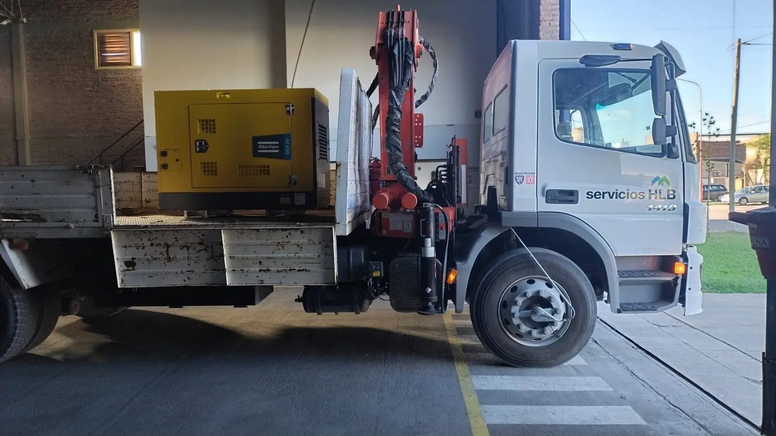 Grupo electrógeno Atlas Copco QES 20 cargado sobre un camión con hidrogrúa