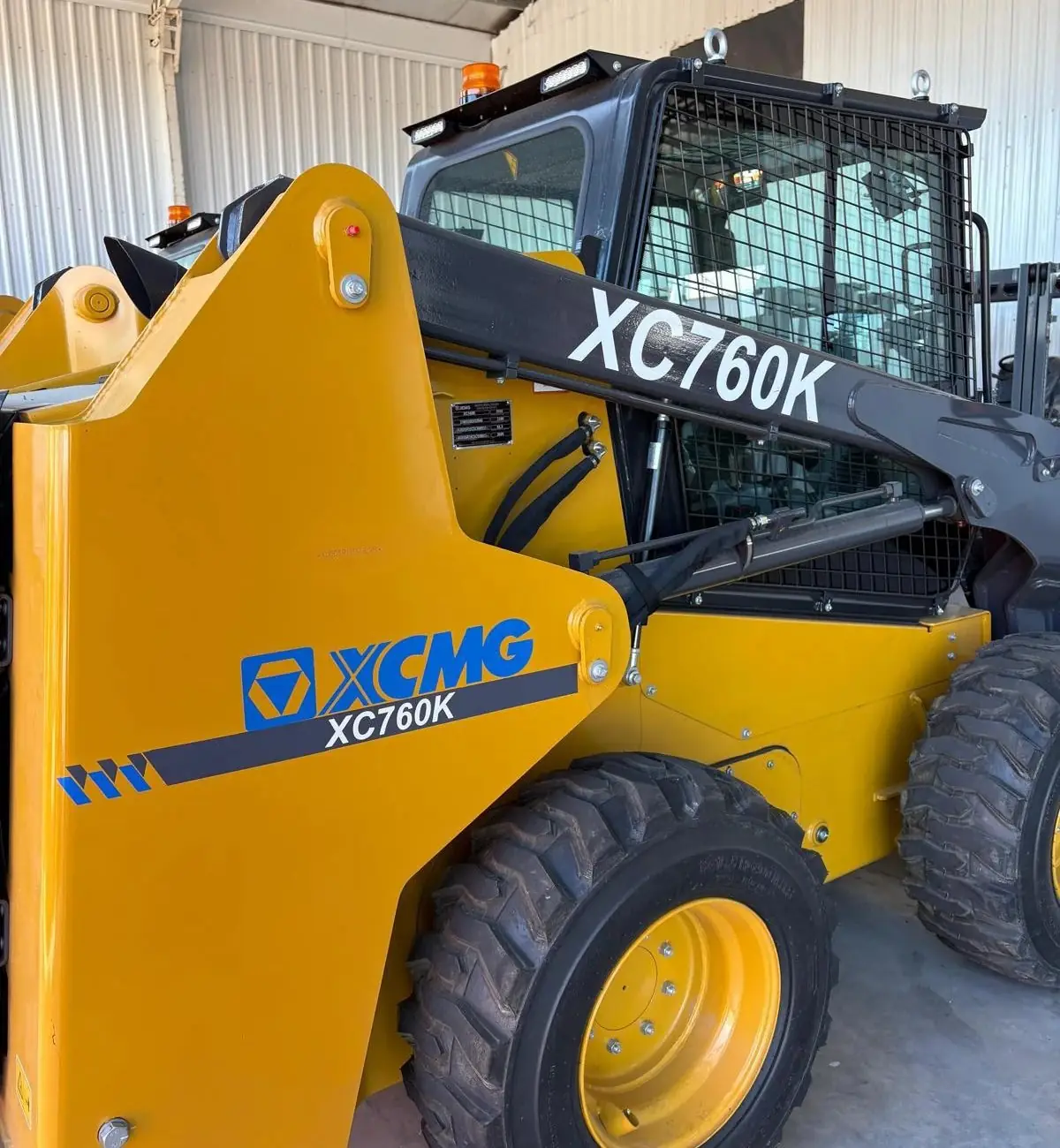 Lateral de una minicargadora XCMG XC760K amarilla con el logo de XCMG