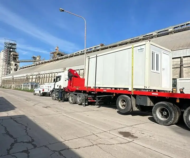 Módulo de Serviwhite sobre semirremolque con hidrogrúa frente a una terminal portuaria de granos