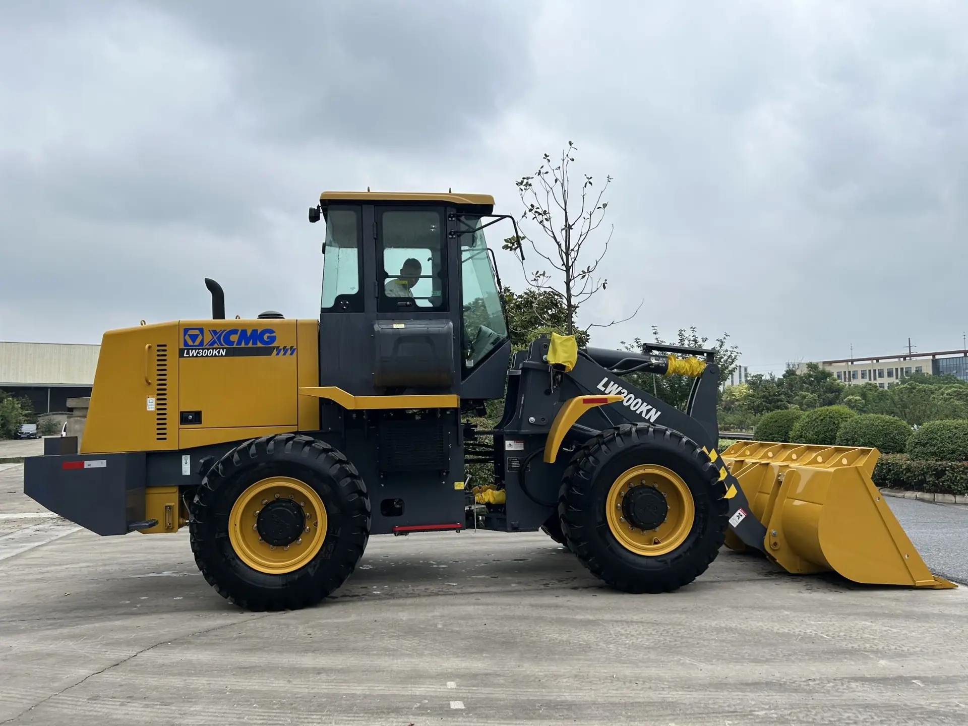 Pala cargadora XCMG LW300KN de perfil con balde amarillo y operador en la cabina