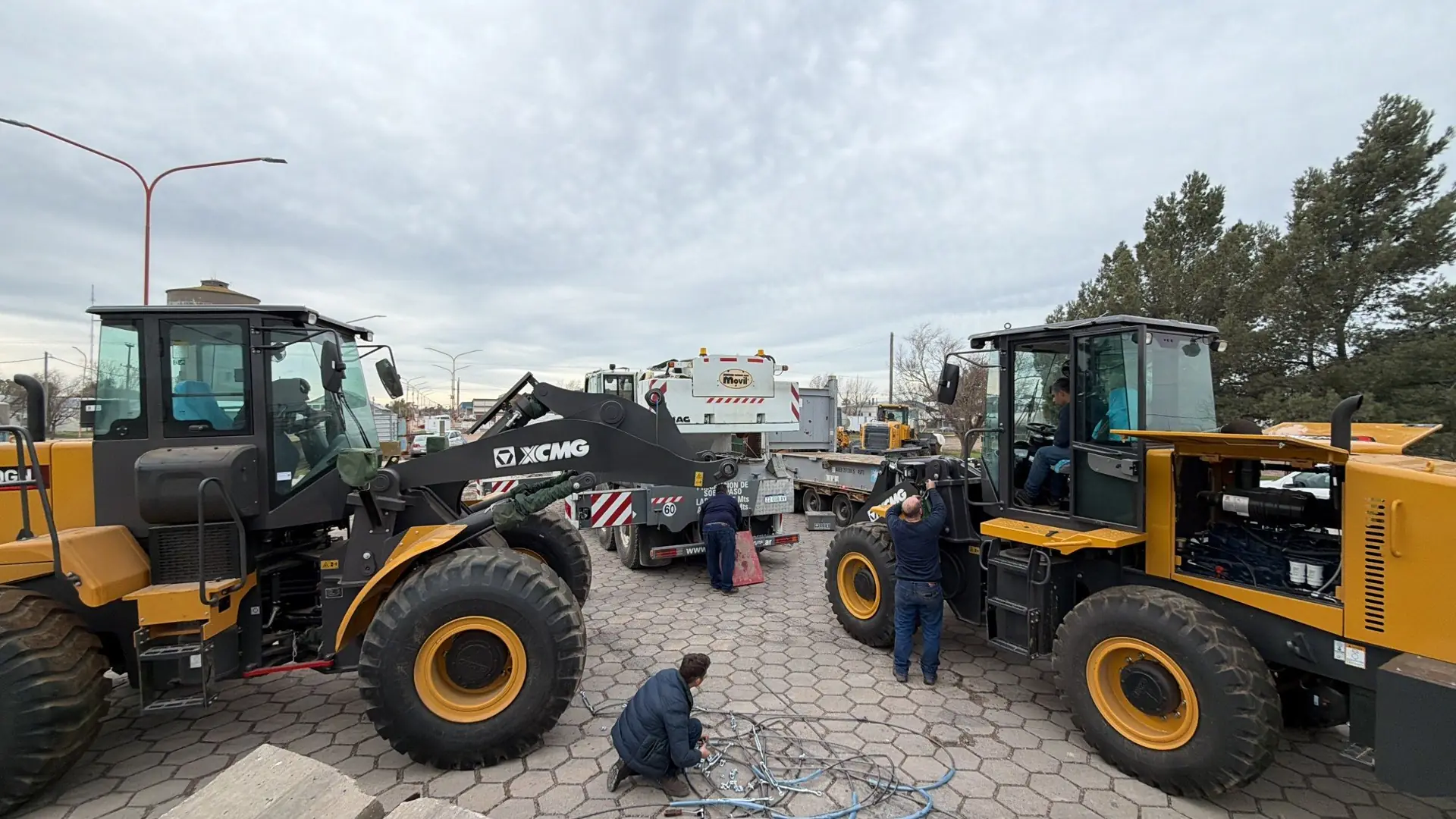 Dos palas cargadoras XCMG enfrentadas mientras operarios de Serviwhite las preparan junto a un camión
