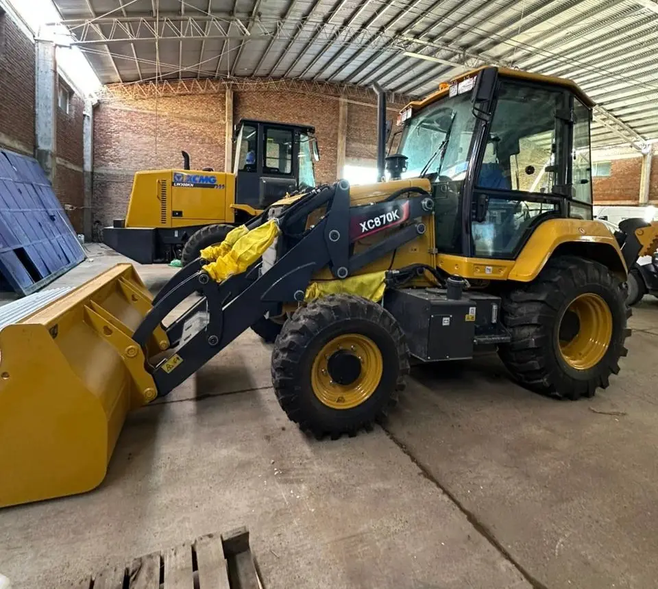Retroexcavadora XCMG XC870K en el galpón, con una pala cargadora XCMG LW300KN detrás