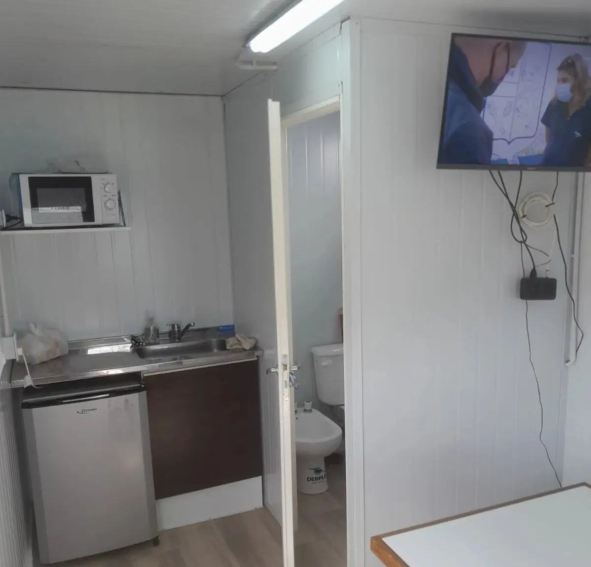 Módulo comedor con bacha, heladera, microondas, televisor y baño