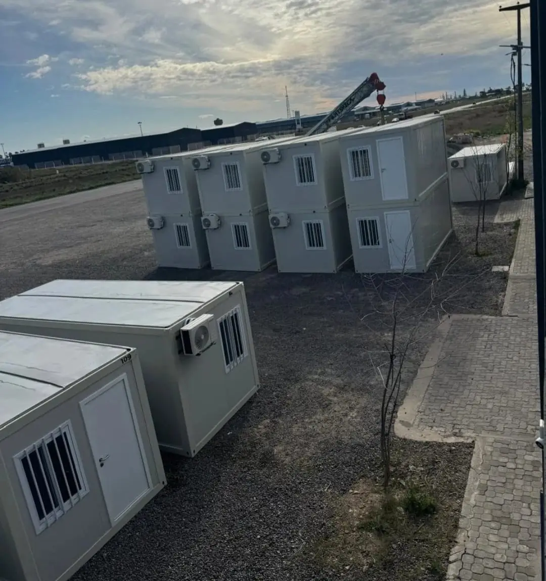 Campamento de módulos apilados en dos niveles con aire acondicionado, montados con grúa en un predio