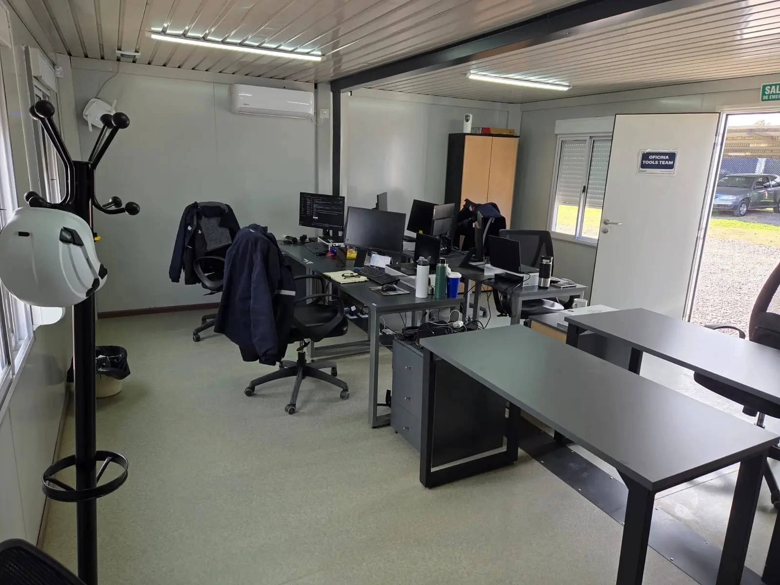 Oficina móvil equipada con escritorios, computadoras, aire acondicionado y armario