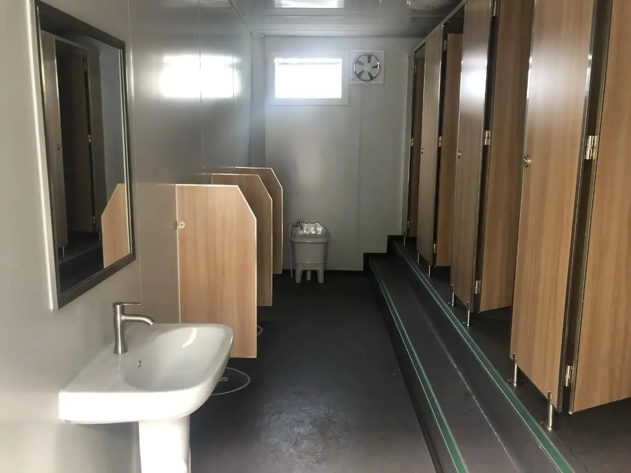Módulo sanitario con lavatorio y espejo, mingitorios con divisores y boxes de inodoro